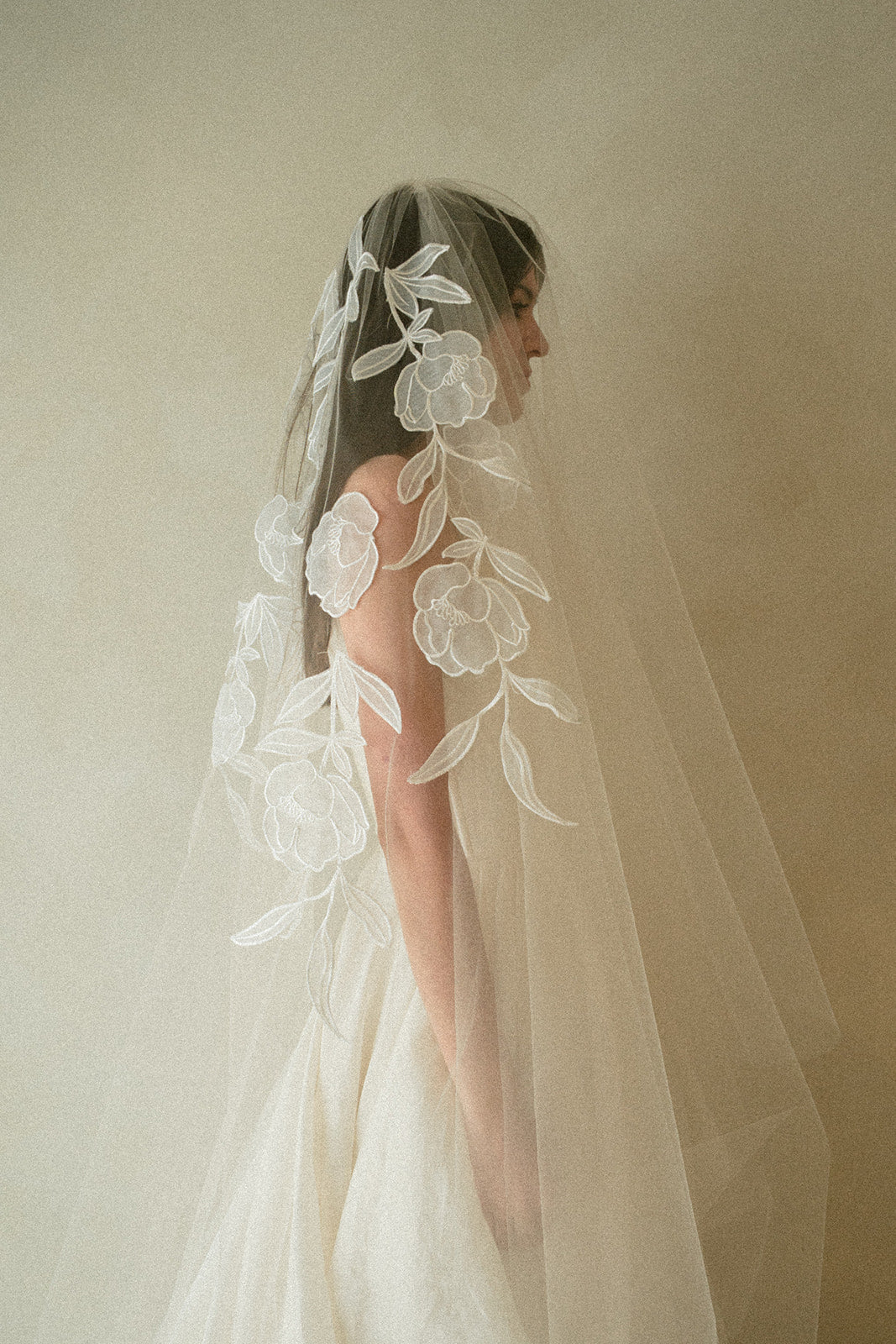 Handcrafted cathedral veil in warm ivory with floral embroidery from crown to fingertip, paired with ivory wedding dress