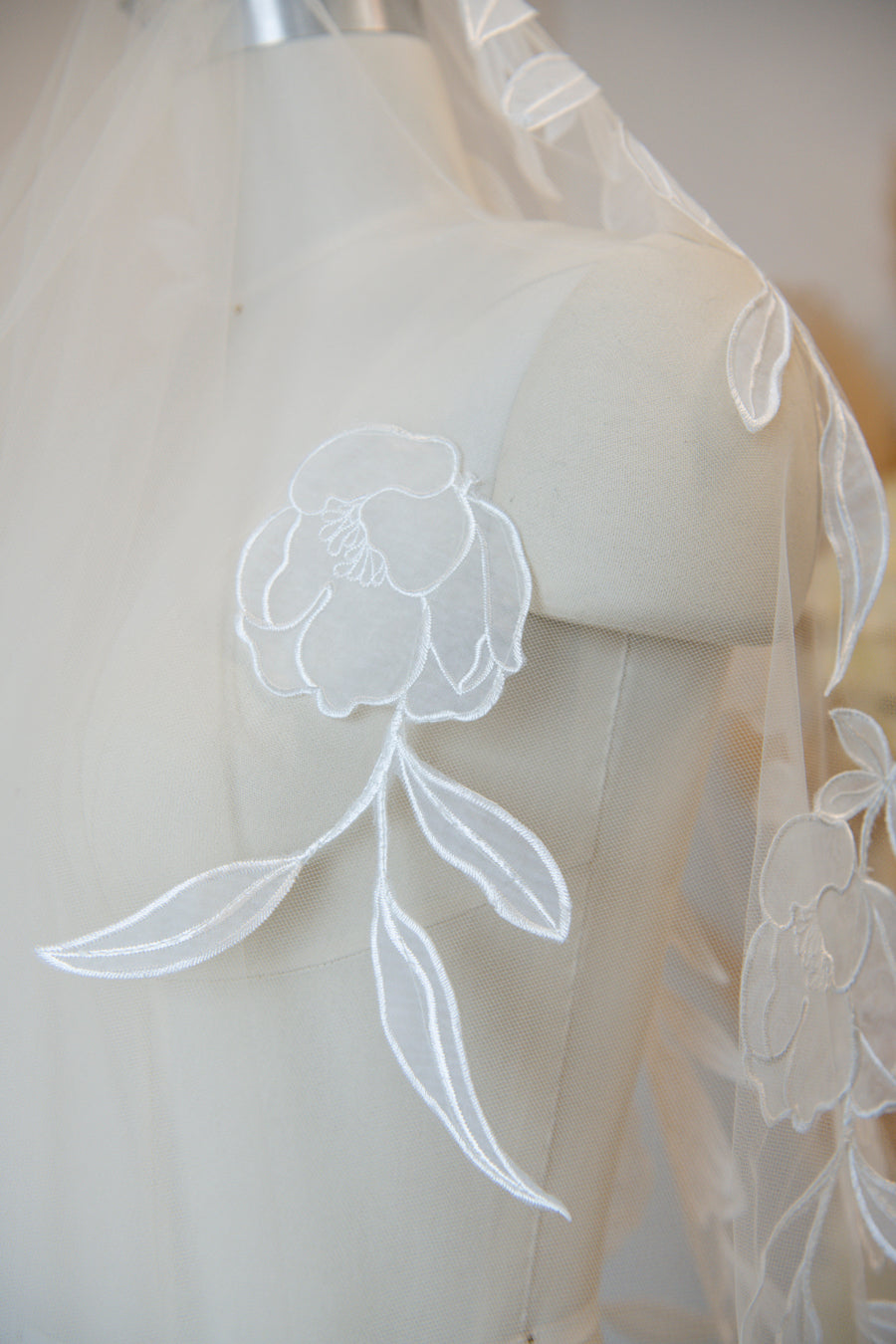 Handcrafted cathedral veil in warm ivory with floral embroidery from crown to fingertip