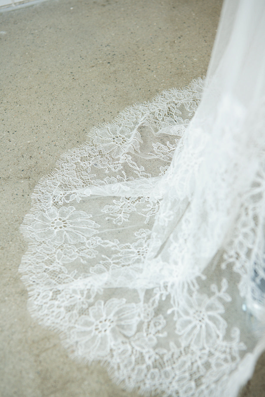 Chapel length silk tulle chantilly lace detail of Amélie veil on floor showing drape