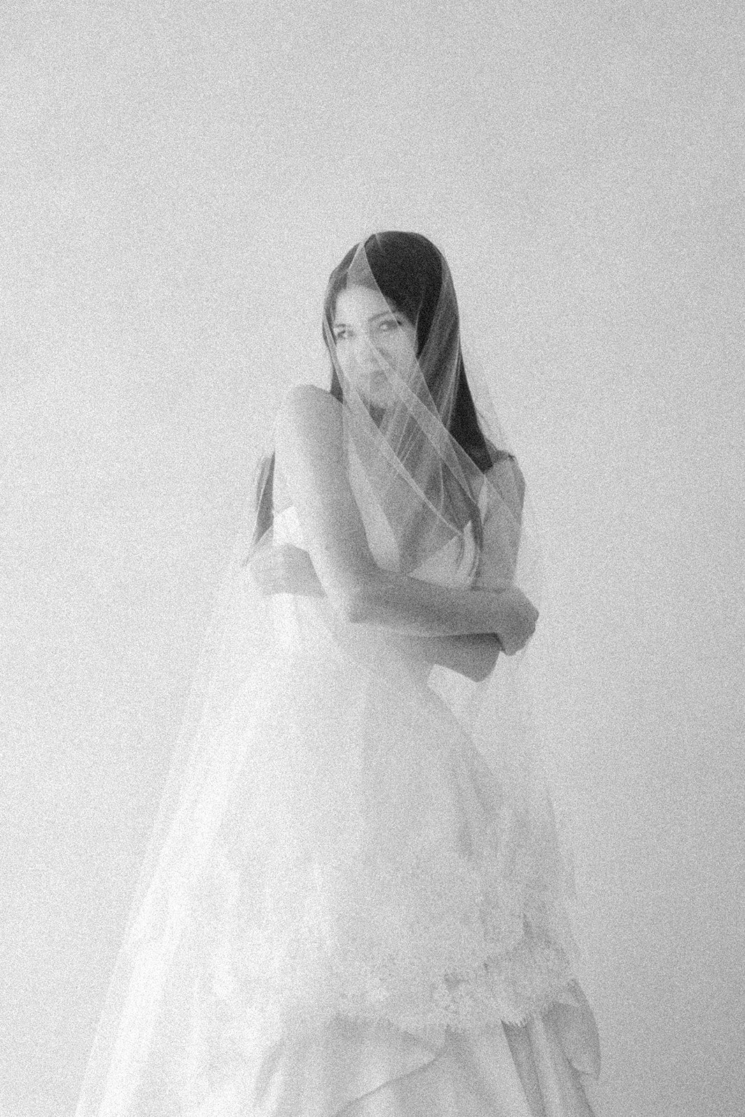 Bride playfully wearing Céleste cathedral mantilla veil with French Leavers lace