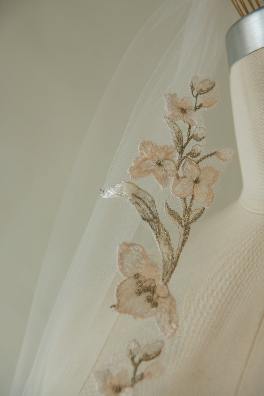 Close-up of embroidered primrose flowers on French tulle veil