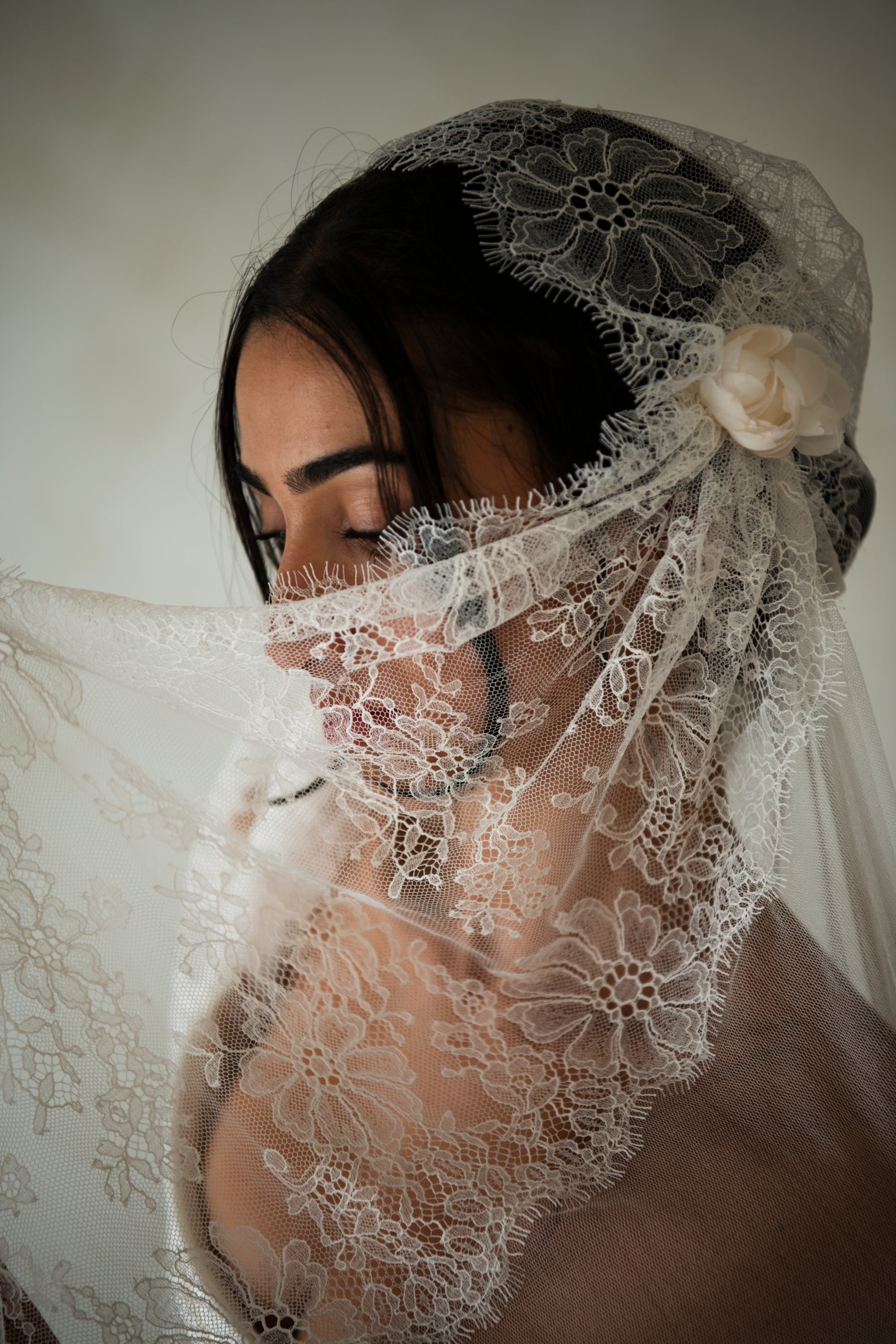 Close-up of Amélie vintage Juliette cap veil with hand-sculpted silk rose buds and chantilly lace on silk tulle
