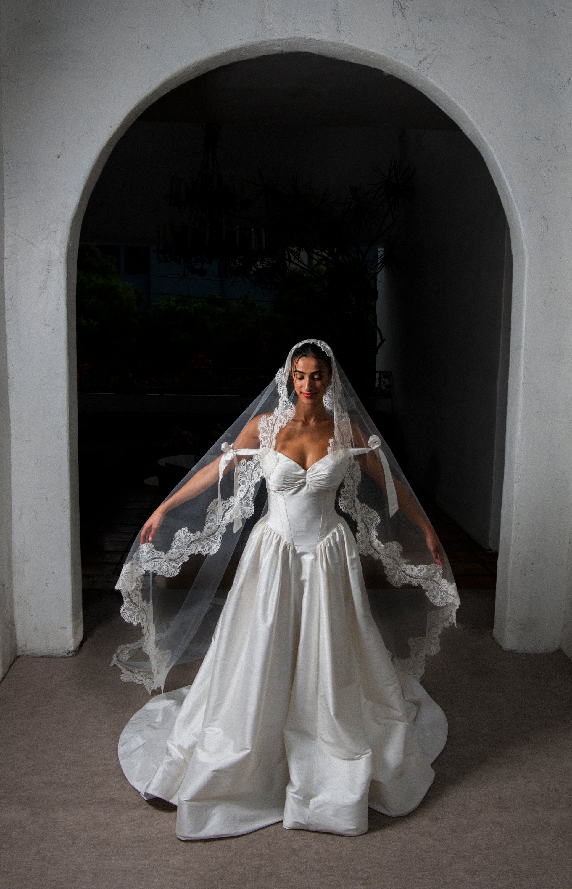 Full length front view of Clair de Lune cathedral mantilla veil with French Leavers lace on a bride wearing vintage basque waist ivory wedding dress