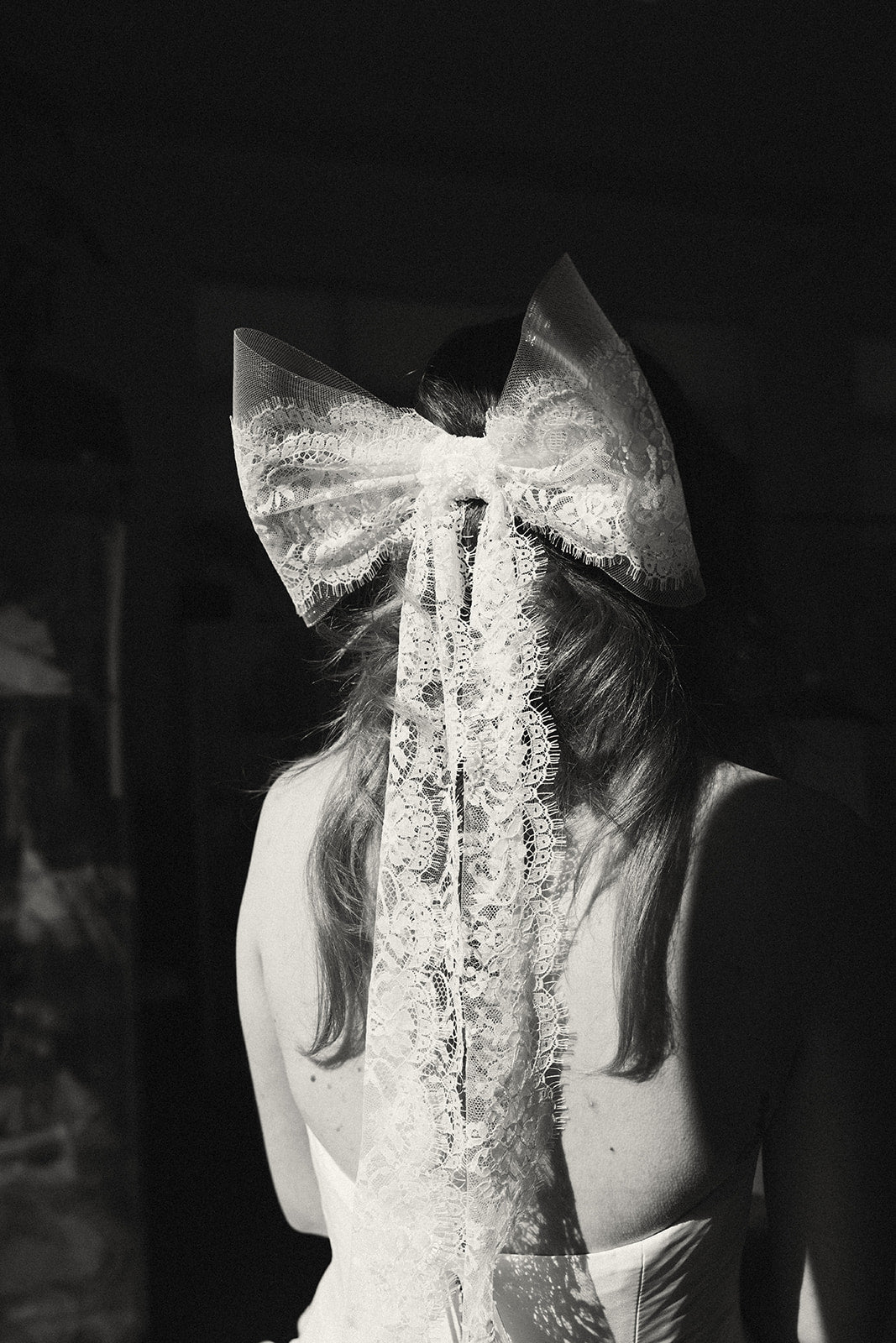 Bride wearing Isla bow veil elbow length back view in black and white