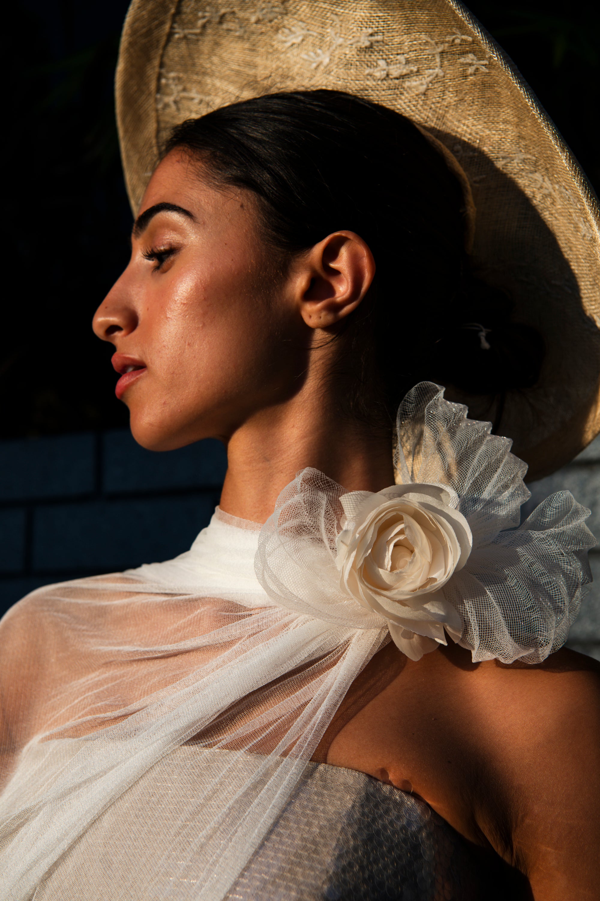 Close-up of Renoncule ranunculus brooch with silk tulle neck scarf on bride